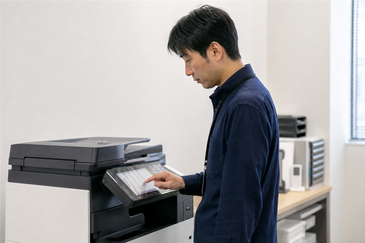 コピー機の操作画面でデータ管理を確認する様子